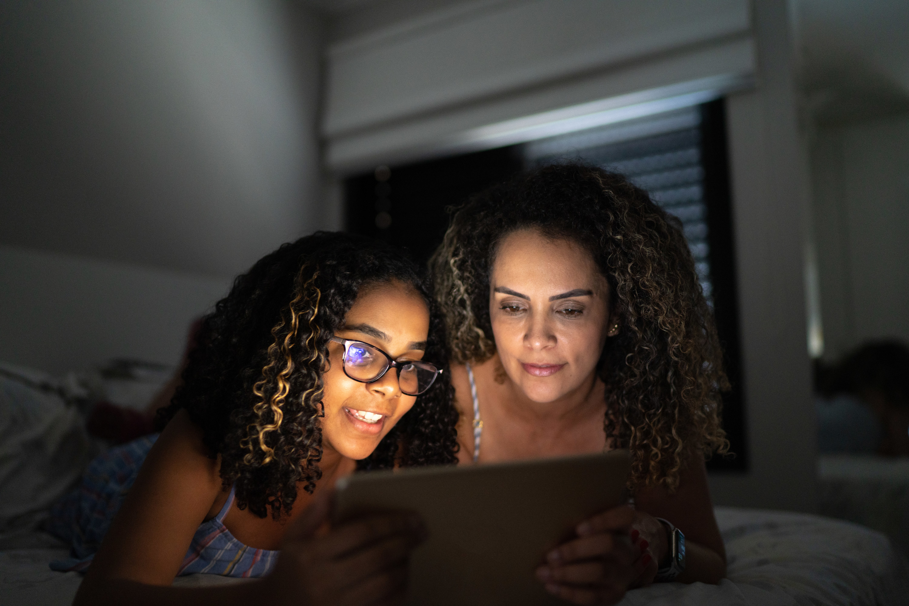 Teen girl and her mom looking for scholarships on a tablet