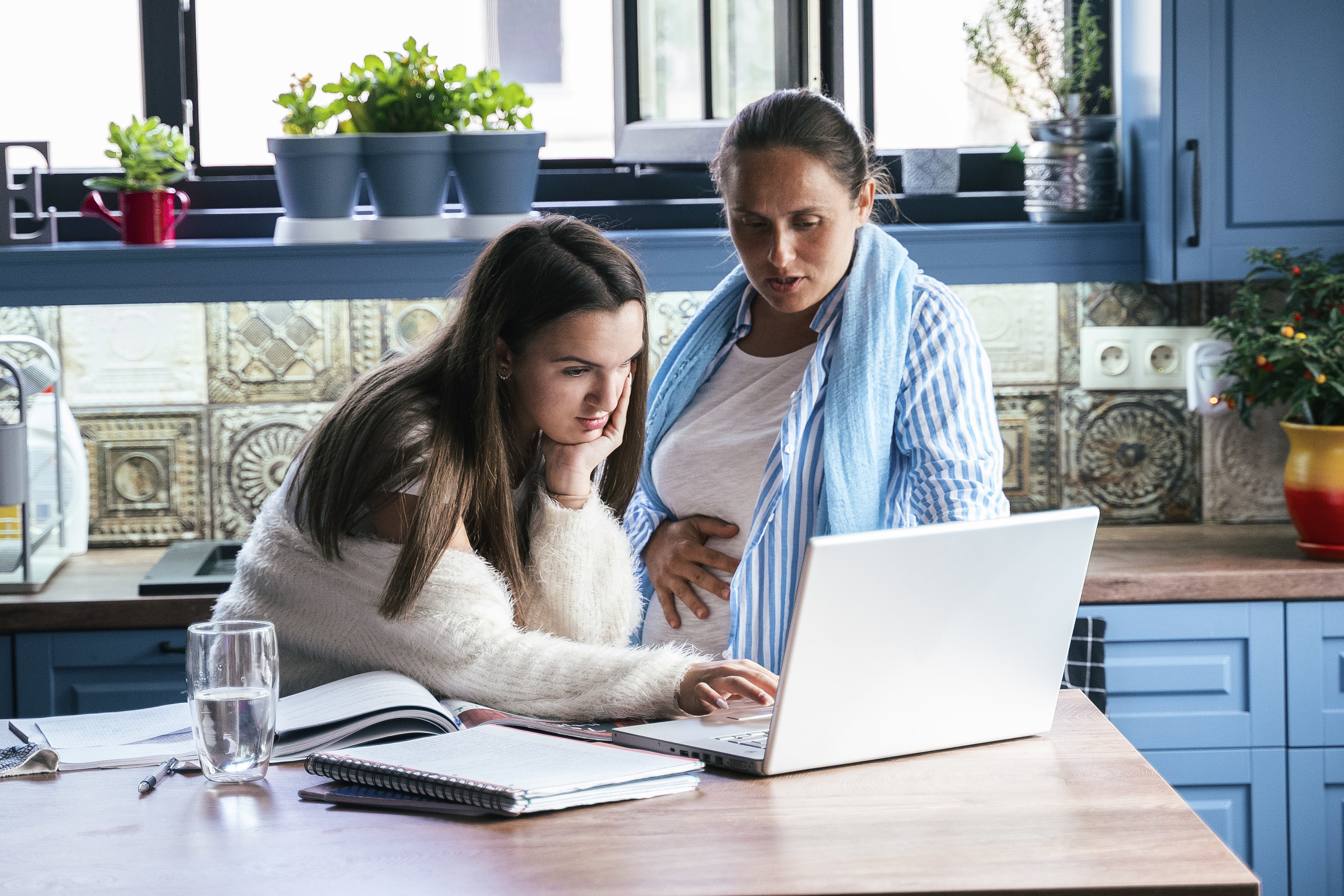 Teen and her mom looking at a laptop