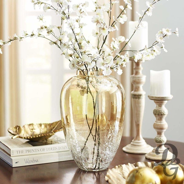 A crackled glass vase with some white flowers kept in it