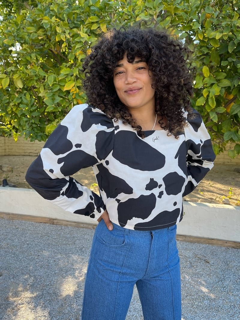 Model wearing the black and white cow print shirt