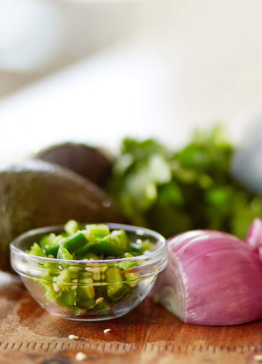 Diced jalapeño in a bowl with onion and avocado.