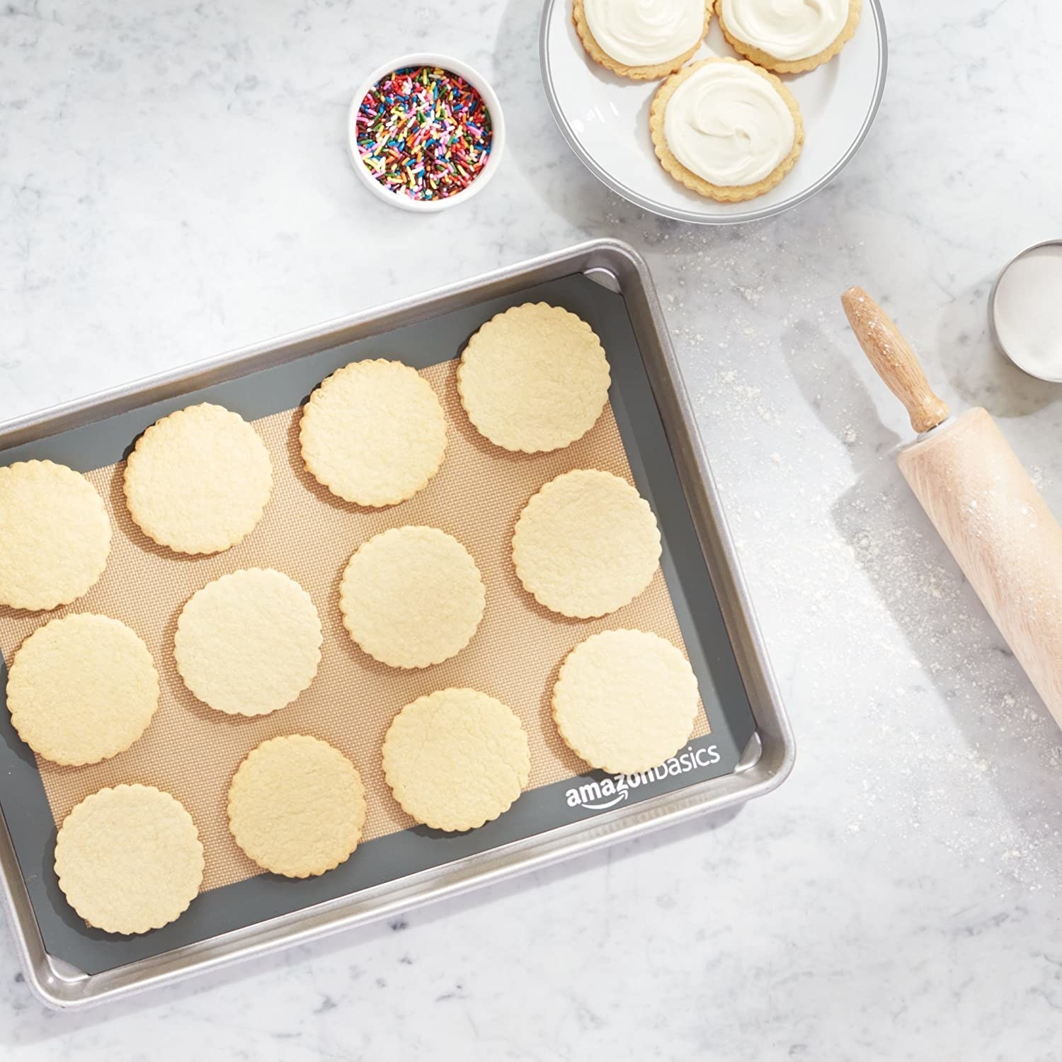 silicone baking mat on a sheet pan with sugar cookies on top