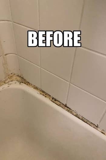 a reviewer photo of a bathtub with dirty caulking