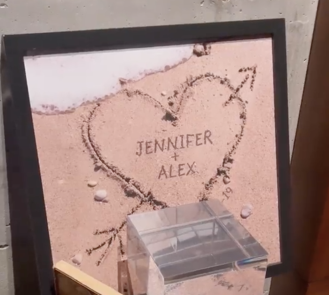 Framed photo of &quot;Jennifer + Alex&quot; in a heart in the sand