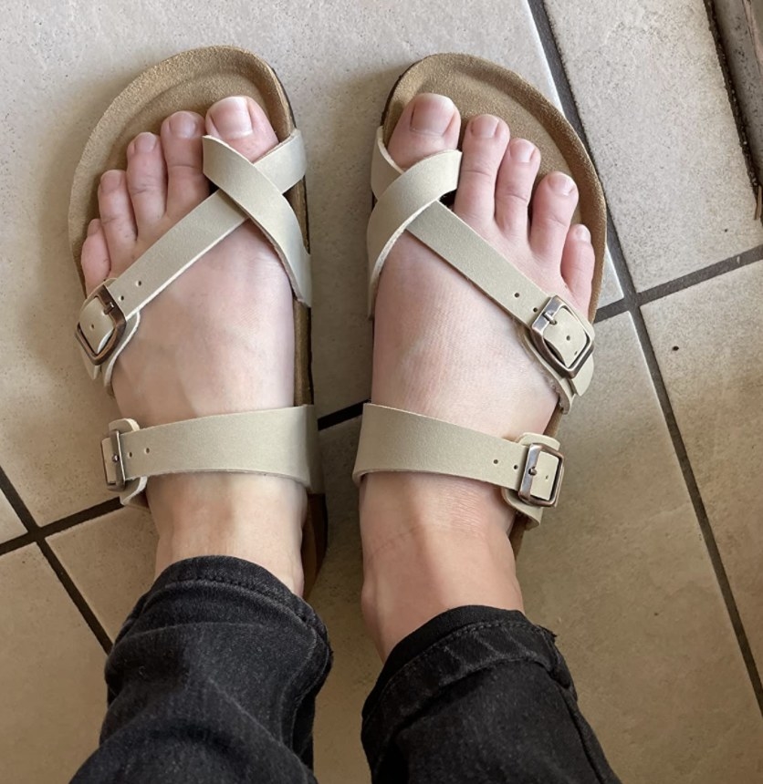 Reviewer photo of the nude sandals with criss cross straps around the toes