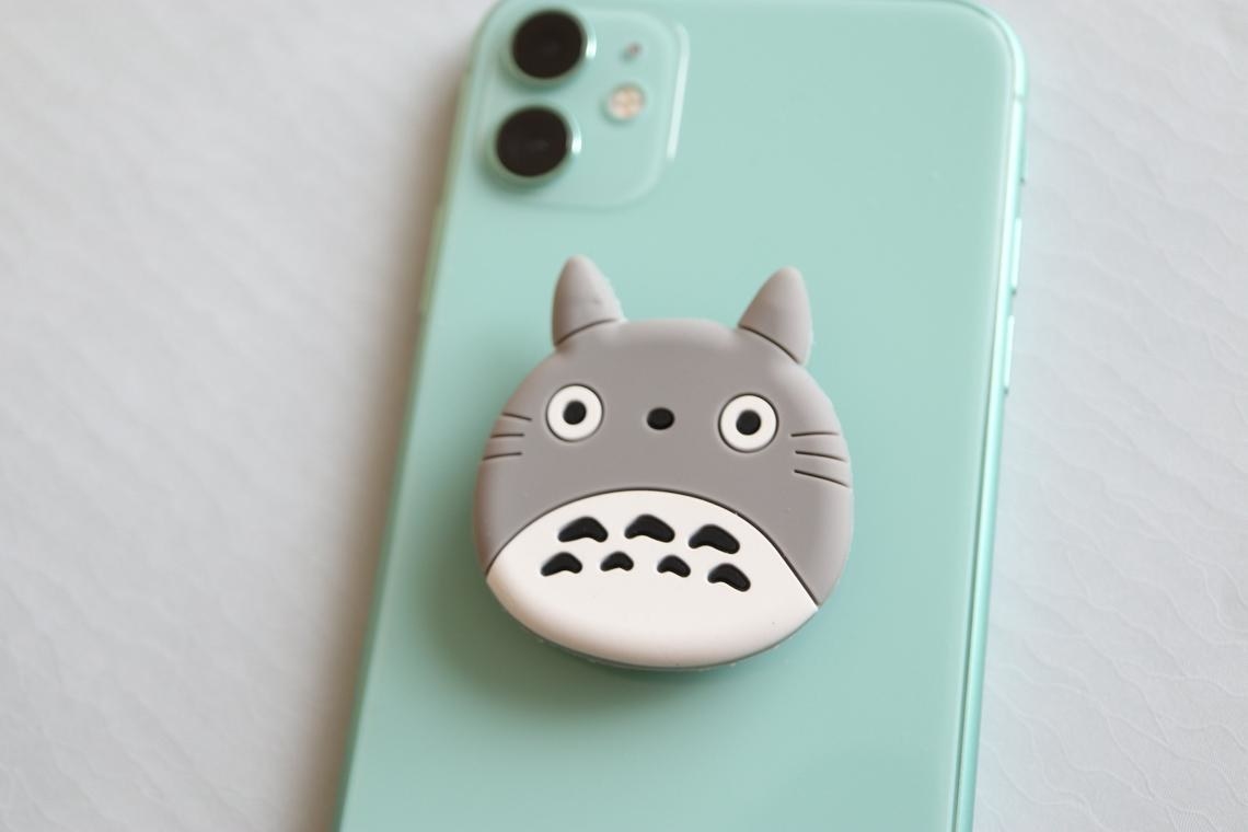 A totoro-shaped popsocket on a vibrant phone case 