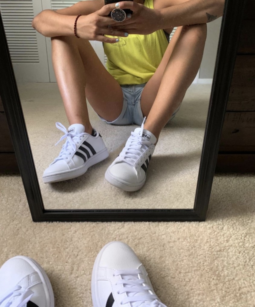 Reviewer photo of the white sneakers with black stripes