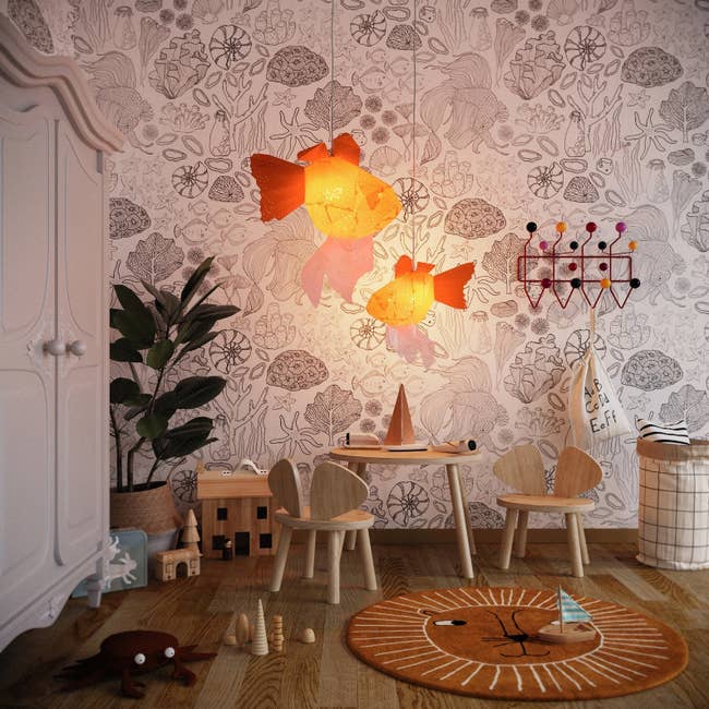 two orange goldfish chandeliers hanging in a kids room