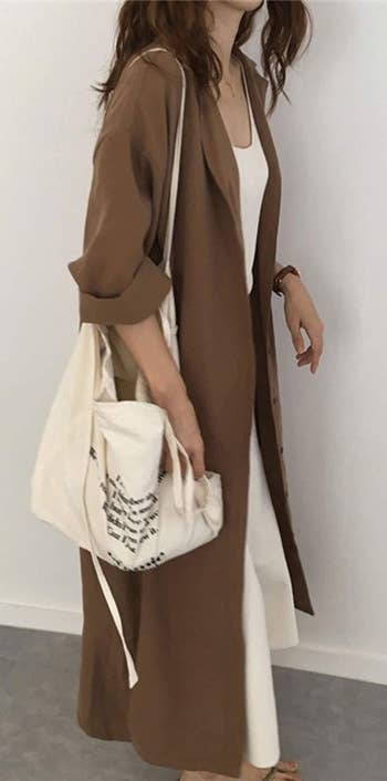 Model wearing brown maxi dress open like a jacket
