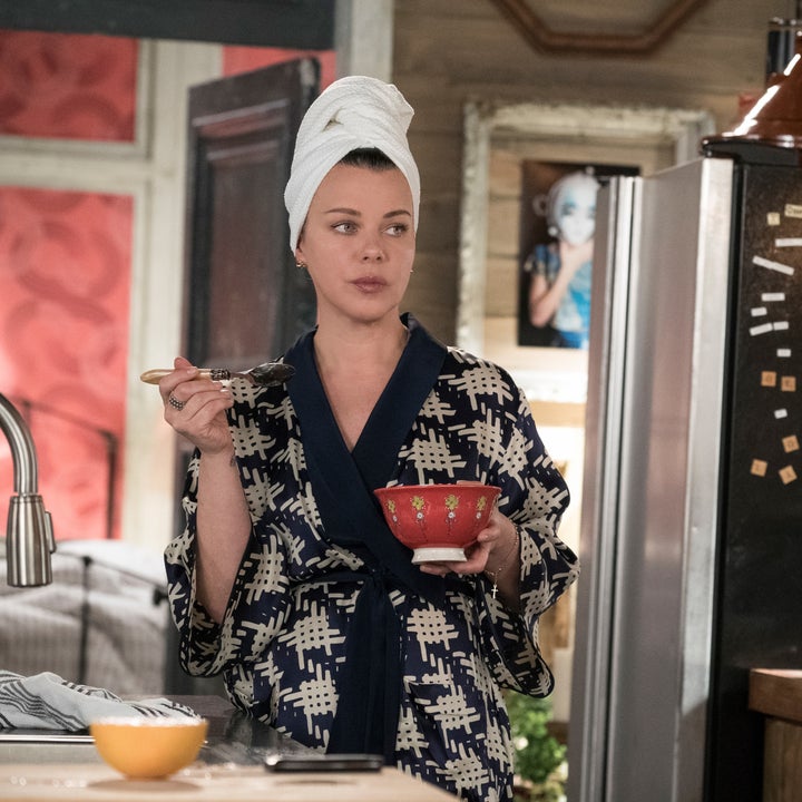 Maggie standing in her kitchen in a bathrobe and towel on her head