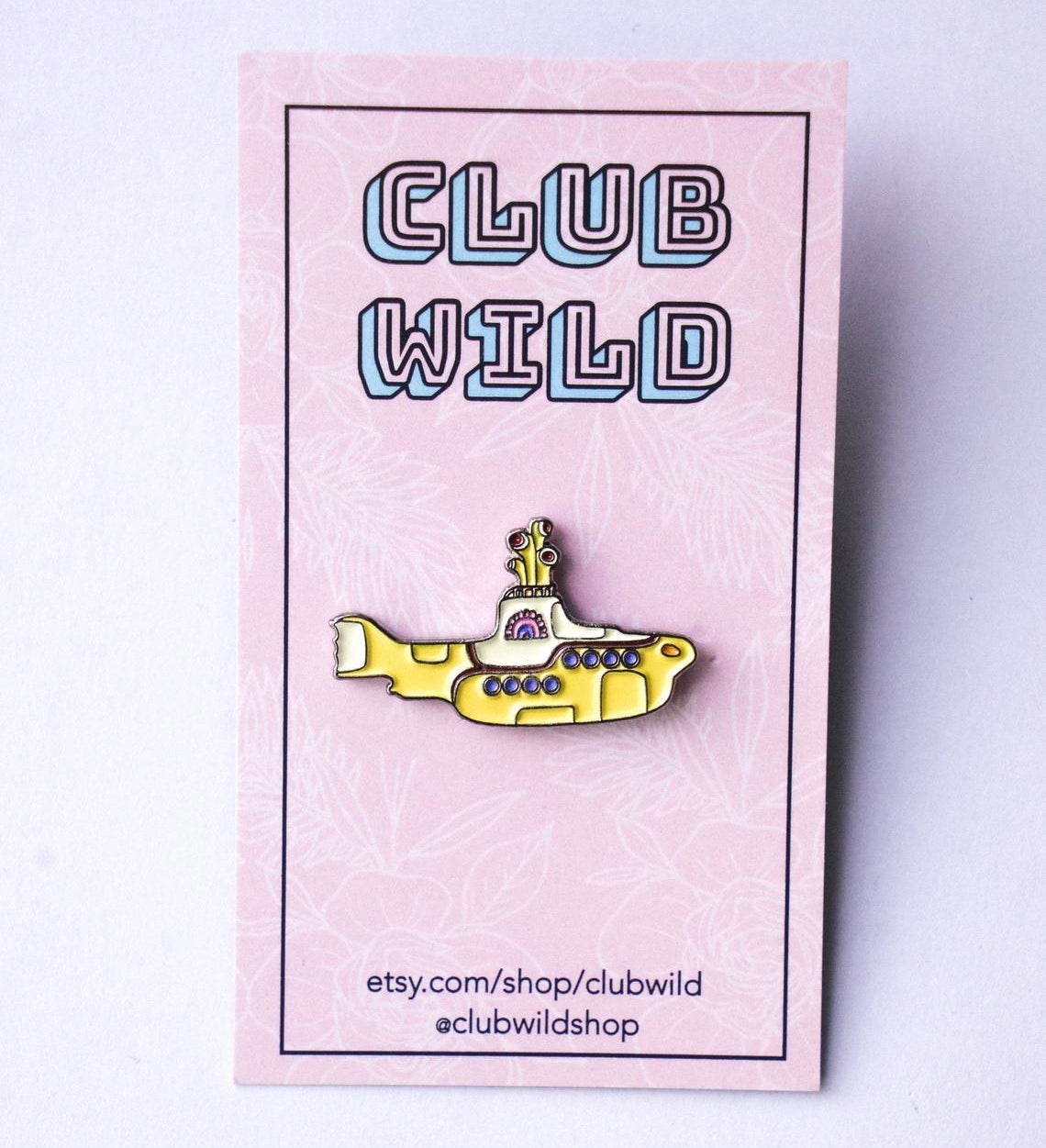 A ceramic yellow submarine pin on a card