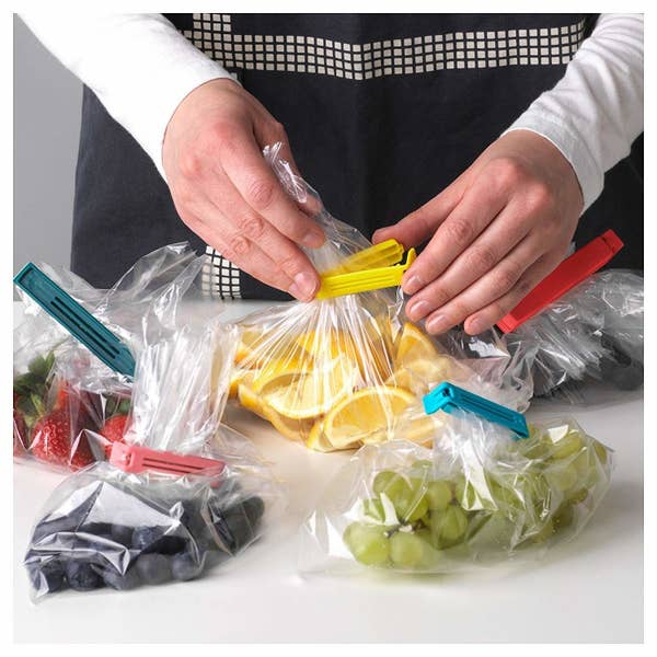 A person sealing bags of fruit with the clips.