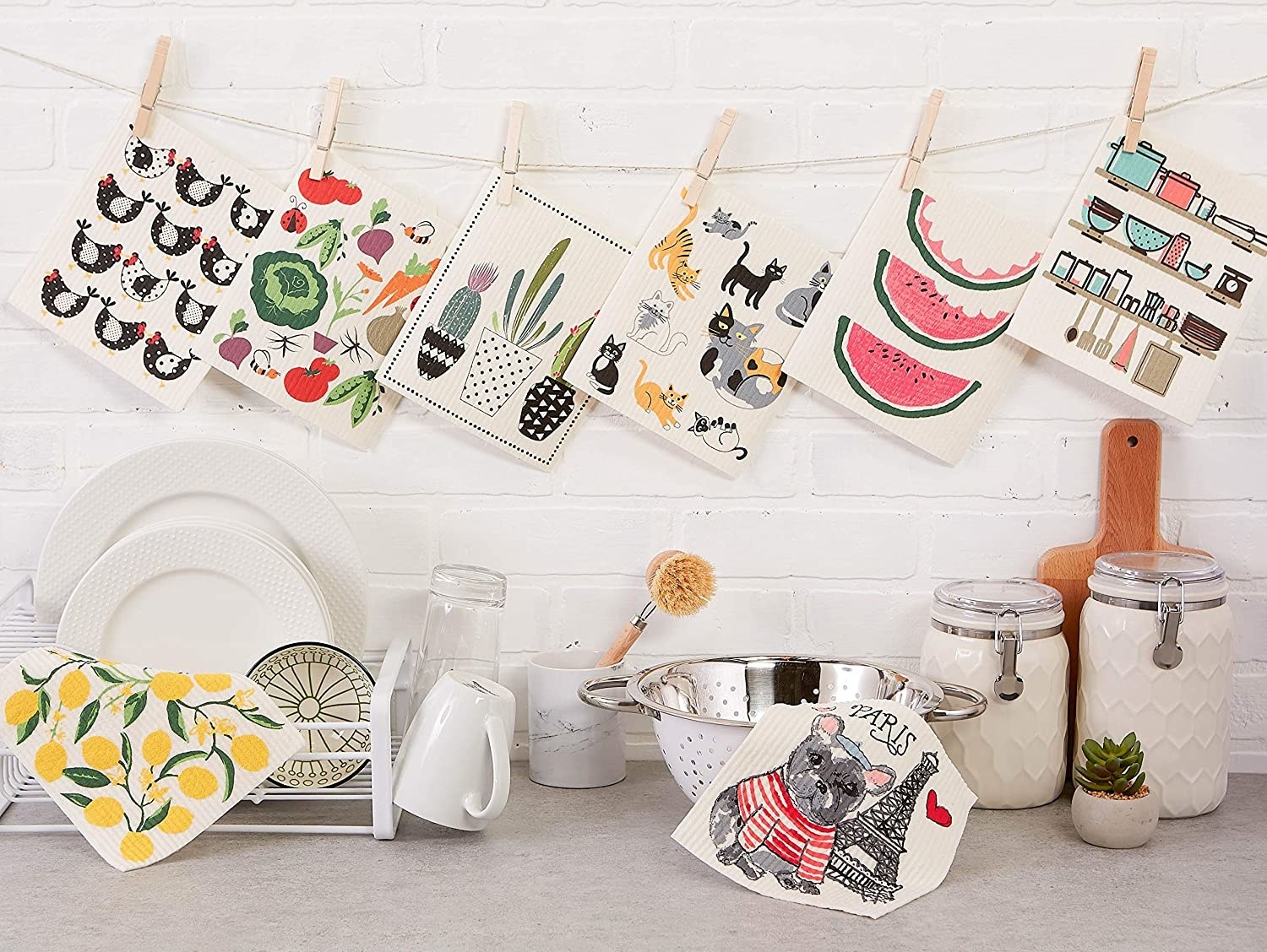 eight kitchen towles with various designs hanging up over a kitchen counter 