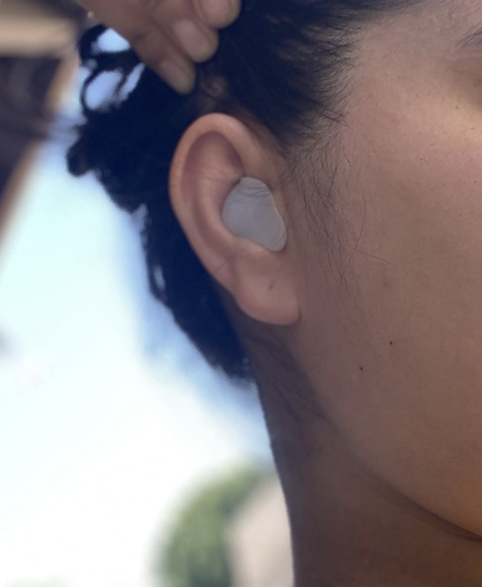 reviewer with close up of the ear plug in ear