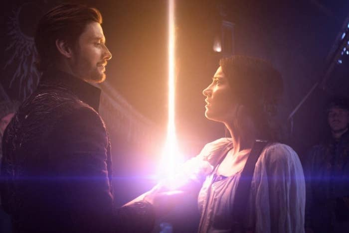 The Darkling and Alina look at each other as a light beam shoots up from Alina's arm