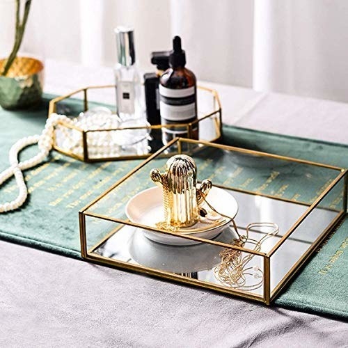 A gold-rimmed vanity tray on a table 