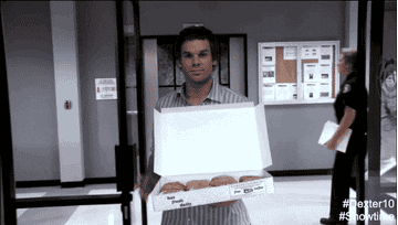 Dexter carrying a box of donuts