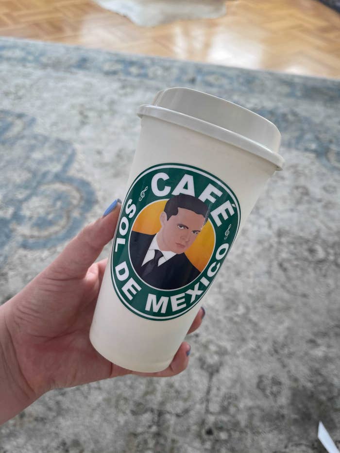 The author holding the coffee cup that says "Cafe Sol De Mexico"