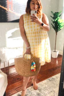reviewer wearing the sleeveless, knee-length, checkered yellow dress 