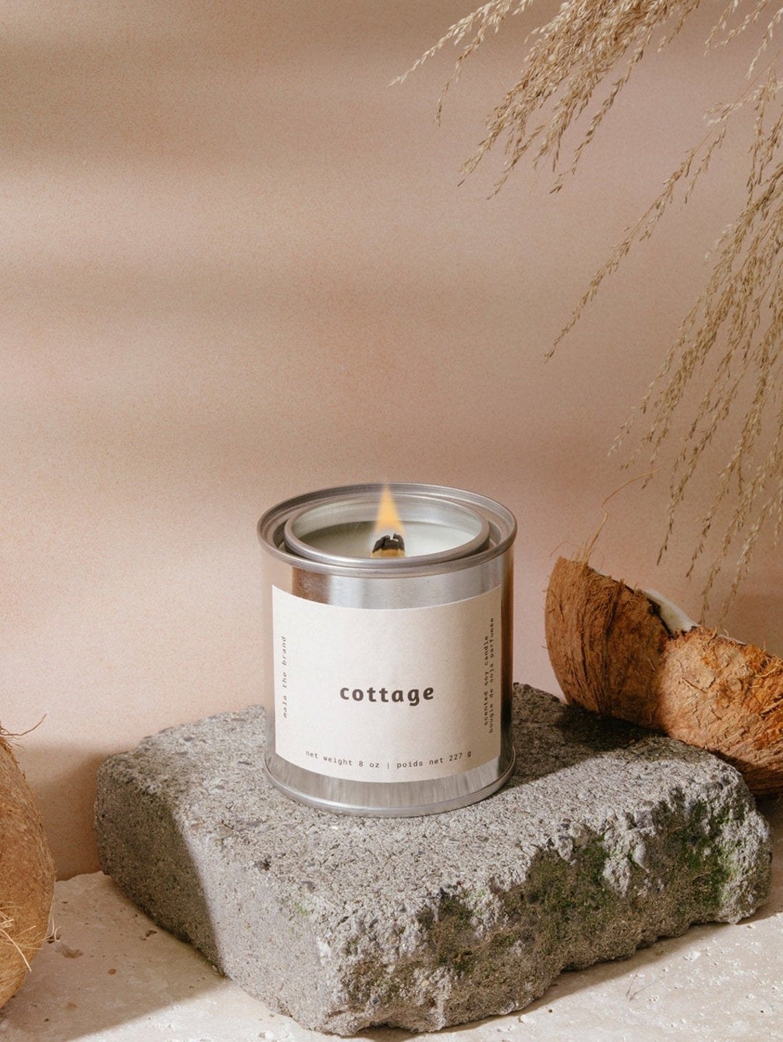 A lit candle in a metal tin