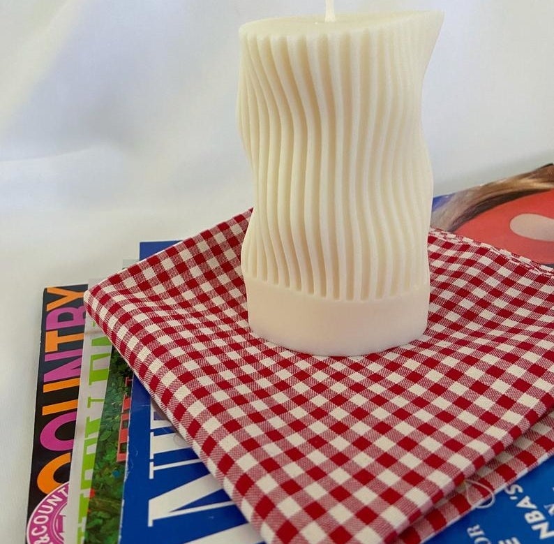 the white candle with vertical stripes and waves