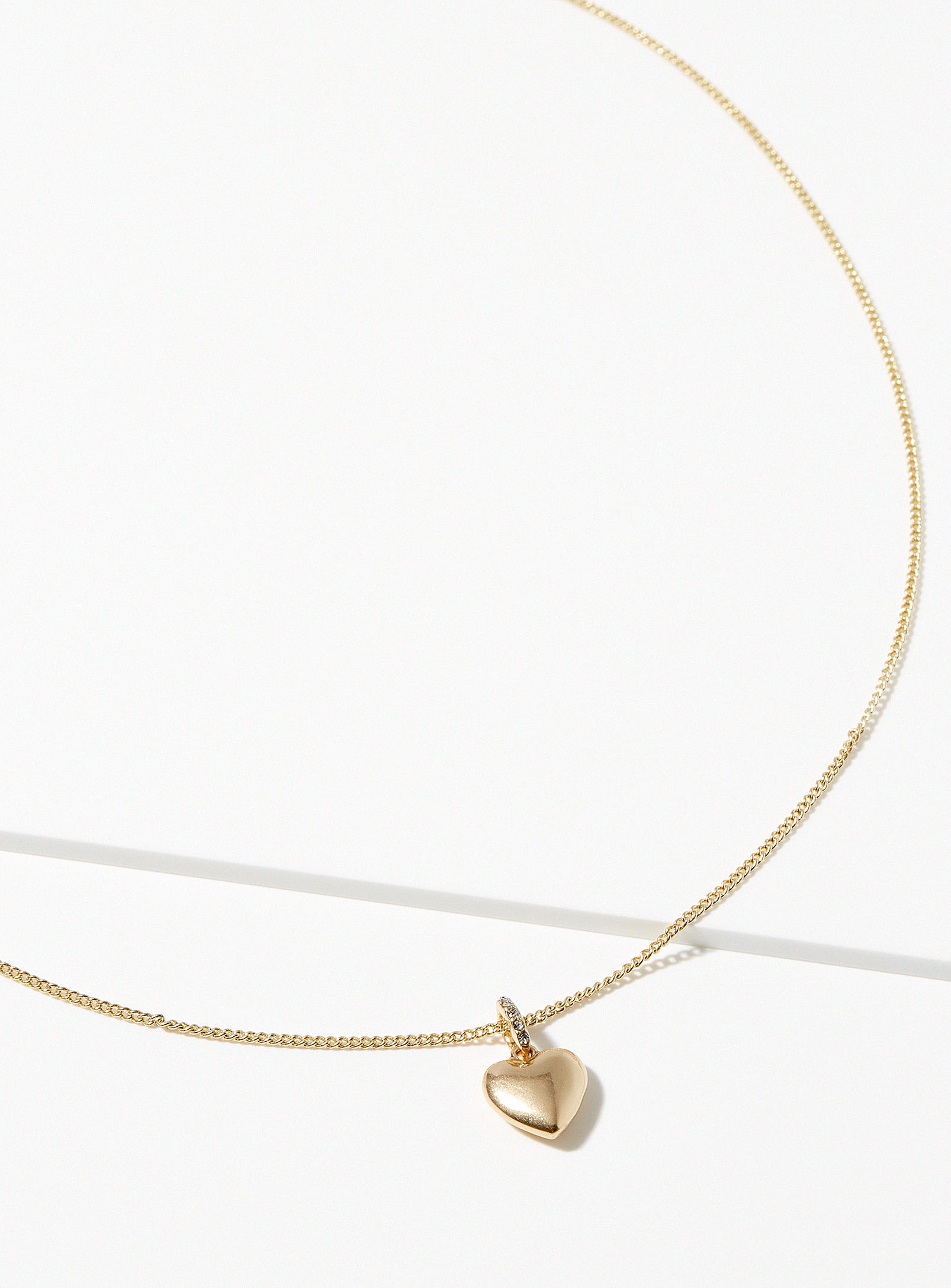 A gold necklace with a heart pendant