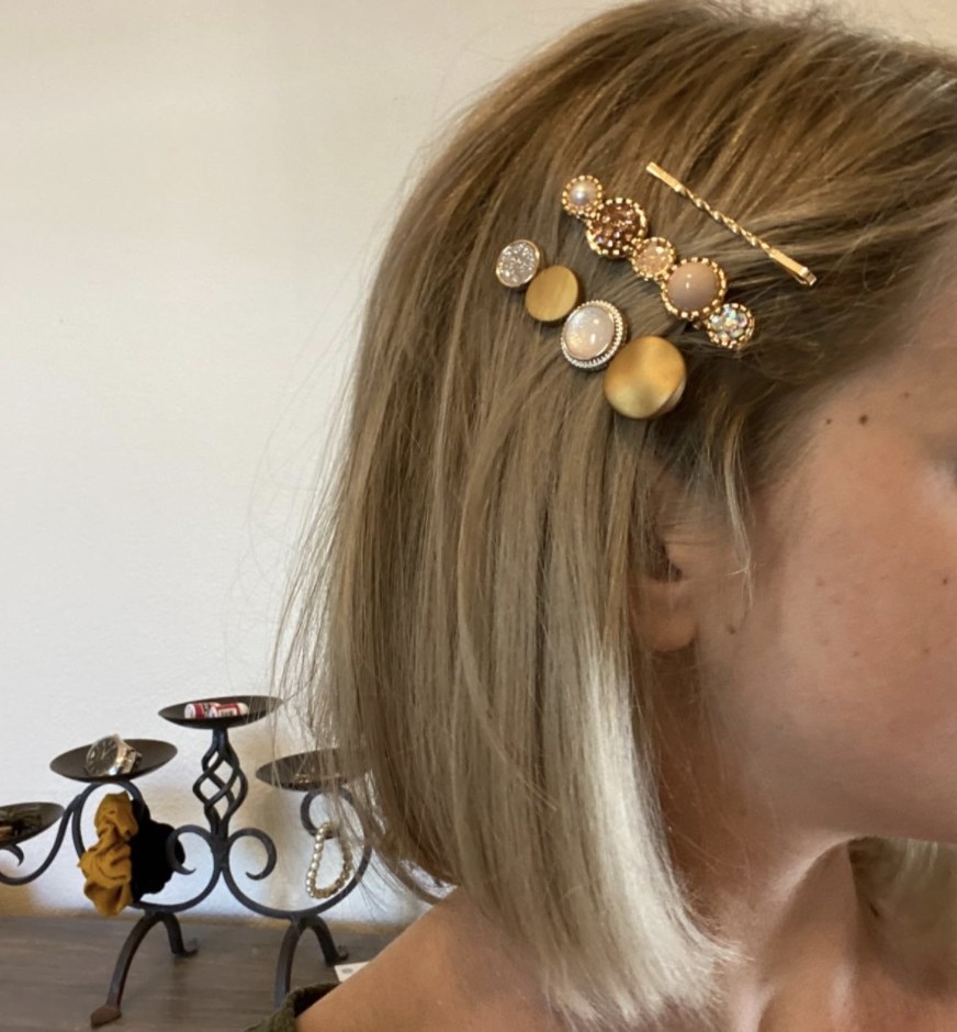 A person wearing three clips in their hair