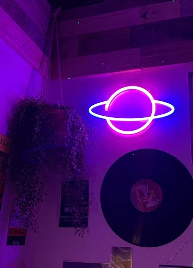 a reviewer's neon planet hanging on the wall