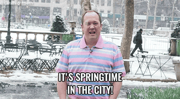 gif of someone standing in the middle of a snowing city spinning around in joy that reads it&#x27;s springtime in the city