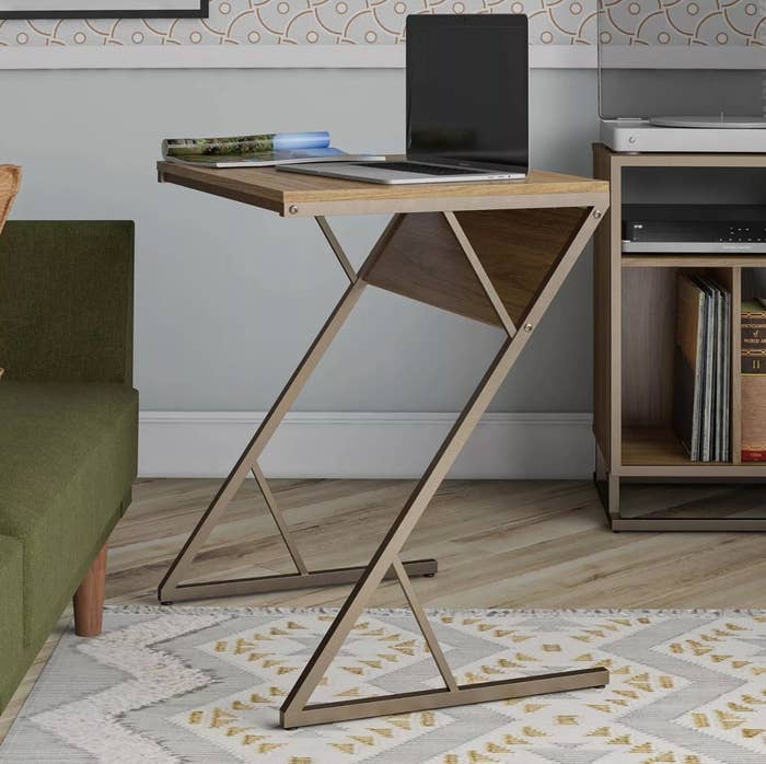 the brown accent table holding a laptop