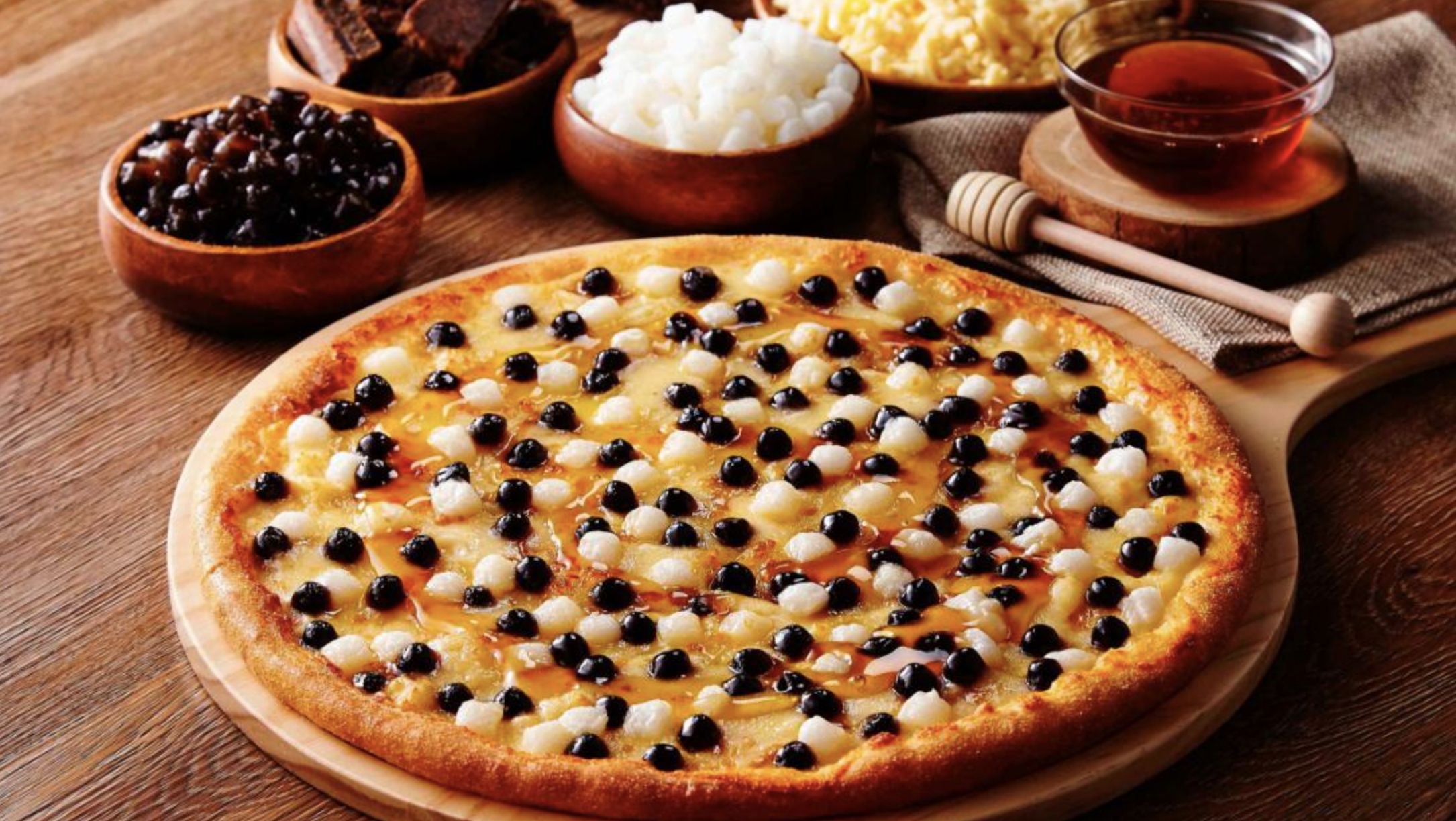 A pizza topped with tapioca balls and cheese