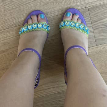 A view of my feet in the shoes from above, showing the sheer toe straps with green stitching and blue and clear jewels