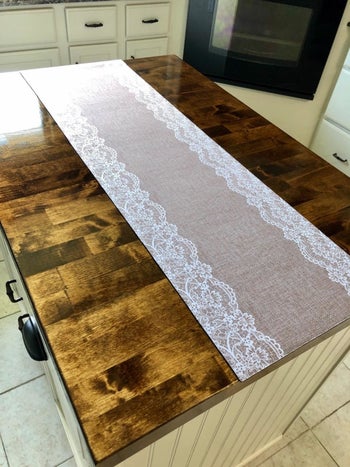 The trivet, which is designed to look like burlap with white lace trim