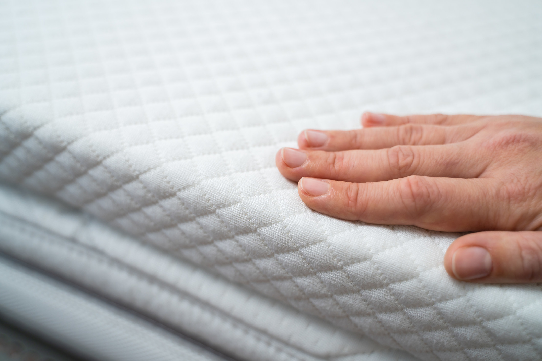 Hand on mattress stock image.