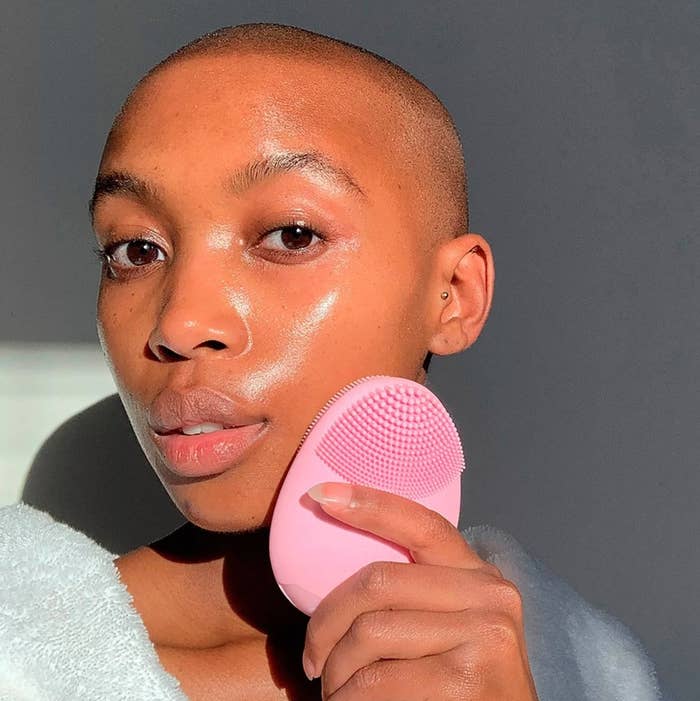 Person washing face with the vibrating facial brush 