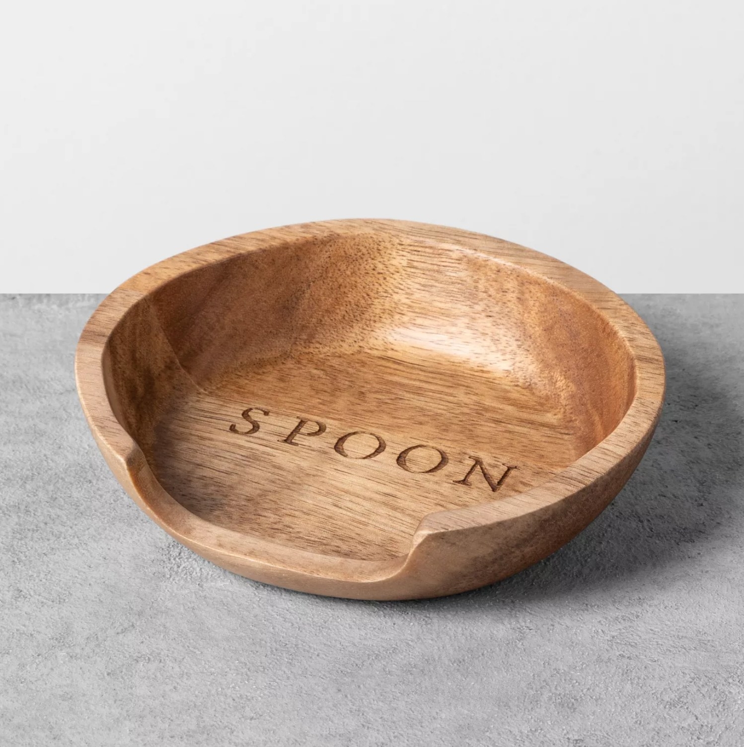 The wooden rest with the word spoon in the center