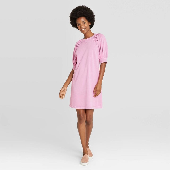 Model wearing pink dress, stops above the knee