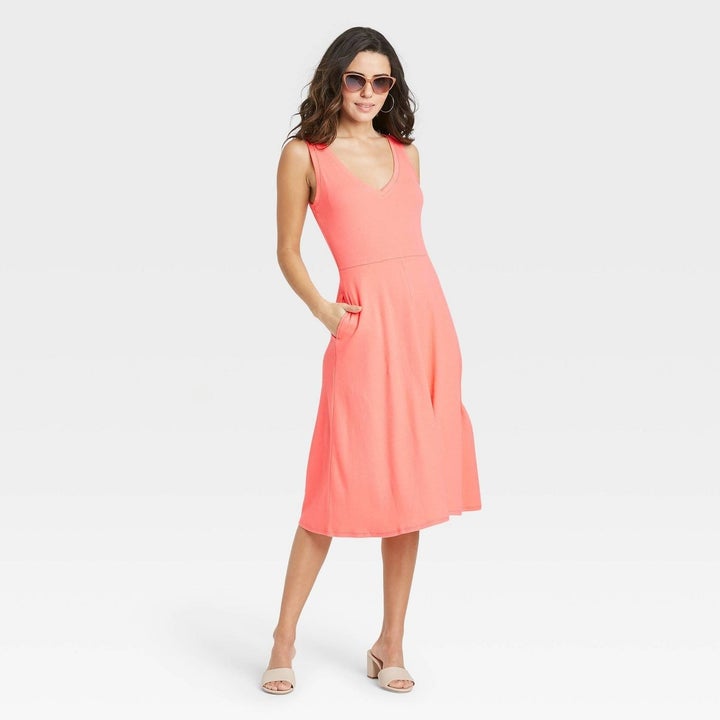 Model wearing coral midi dress with side pocket