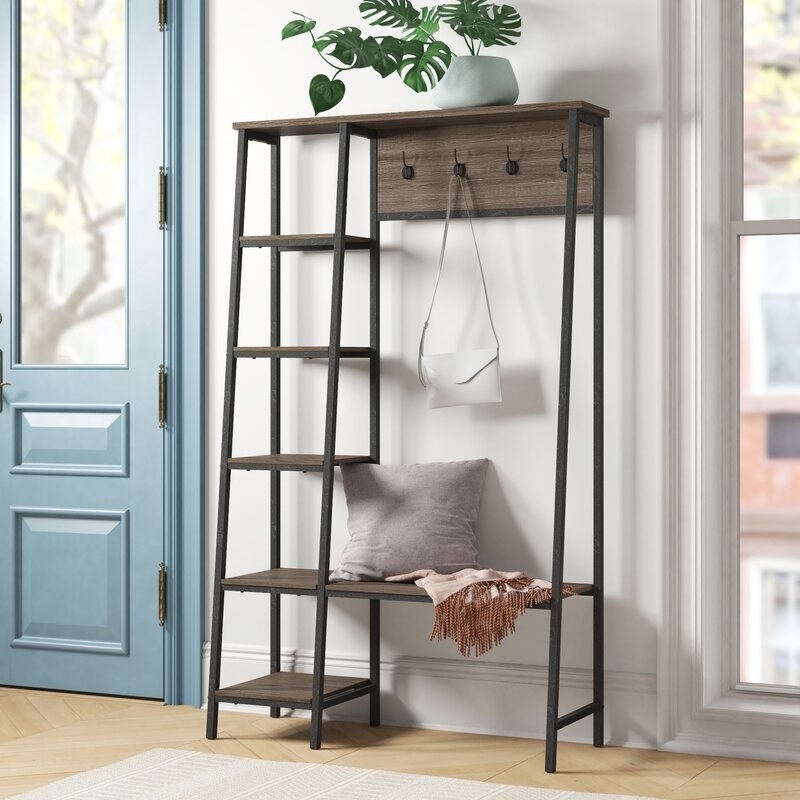 A wood and steel entryway tree with a 5-shelf ladder, 4 hooks, a top shelf, and a bench 