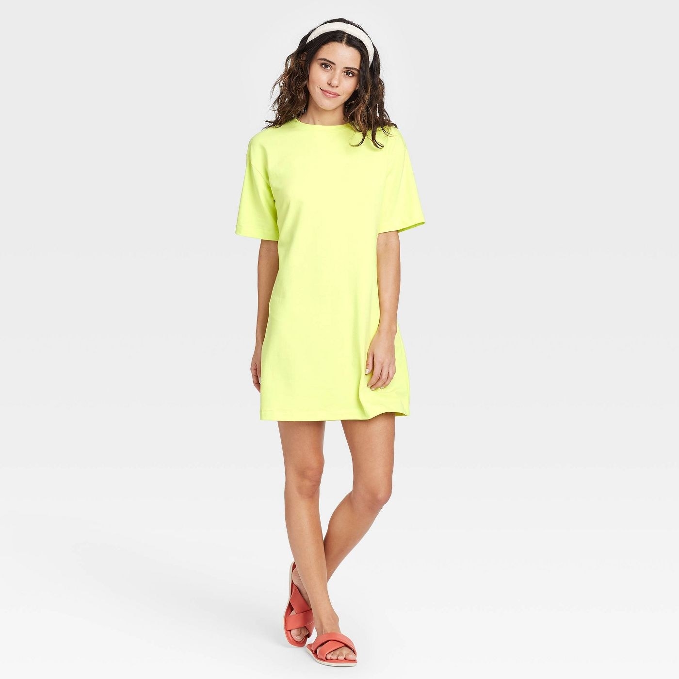 Model wearing neon yellow dress, goes past the thigh
