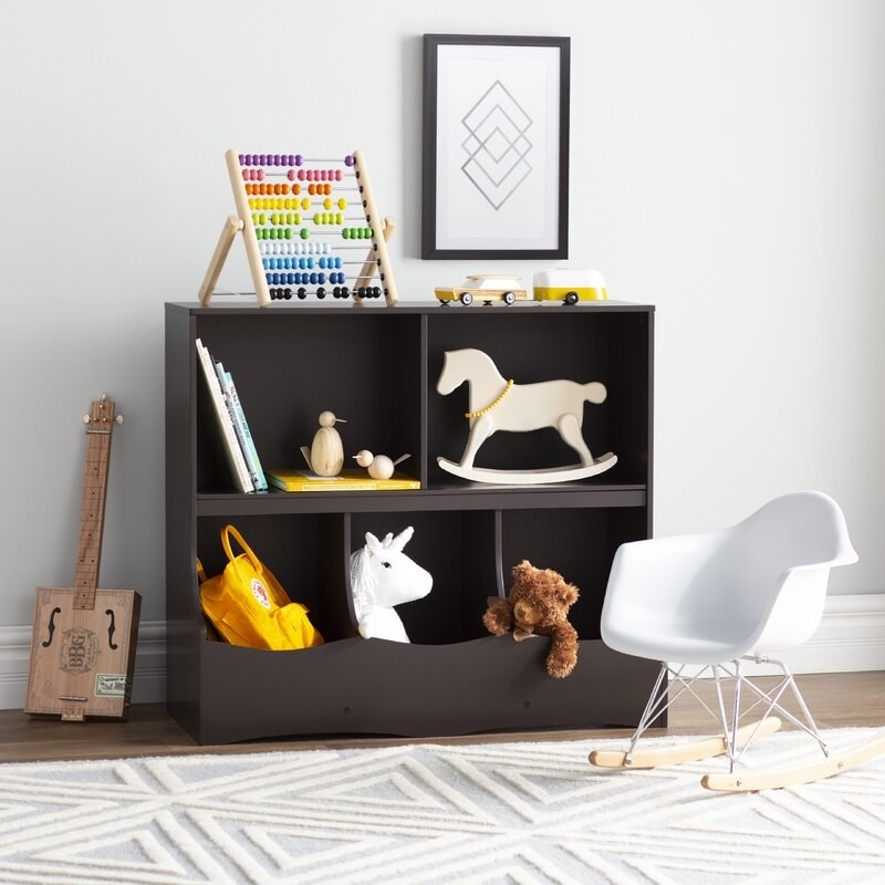 A wooden toy organizer with 3 cubbies and two shelves to hold toys, stuffed animals, and books