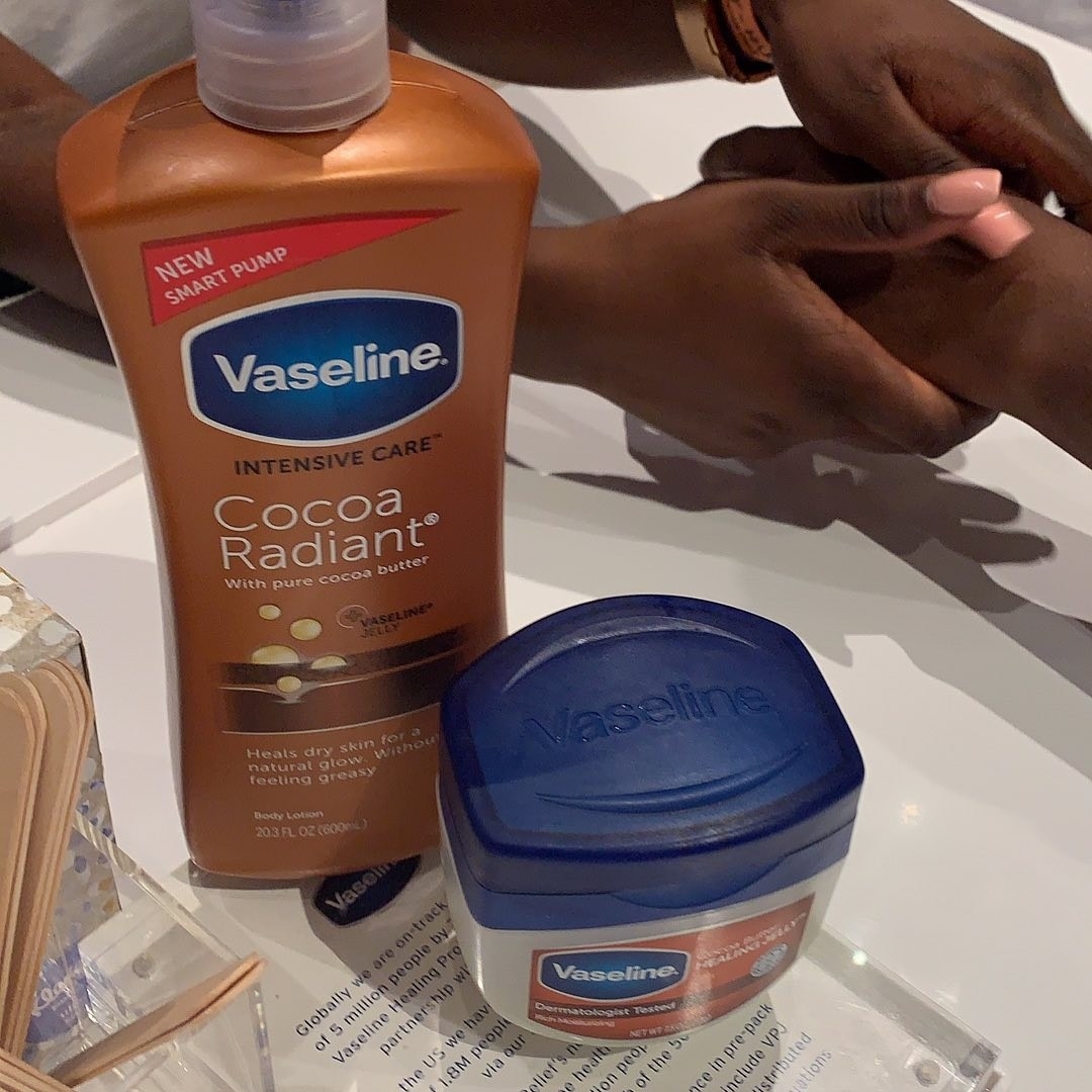 Bottle of vaseline cocoa butter with legs in the back