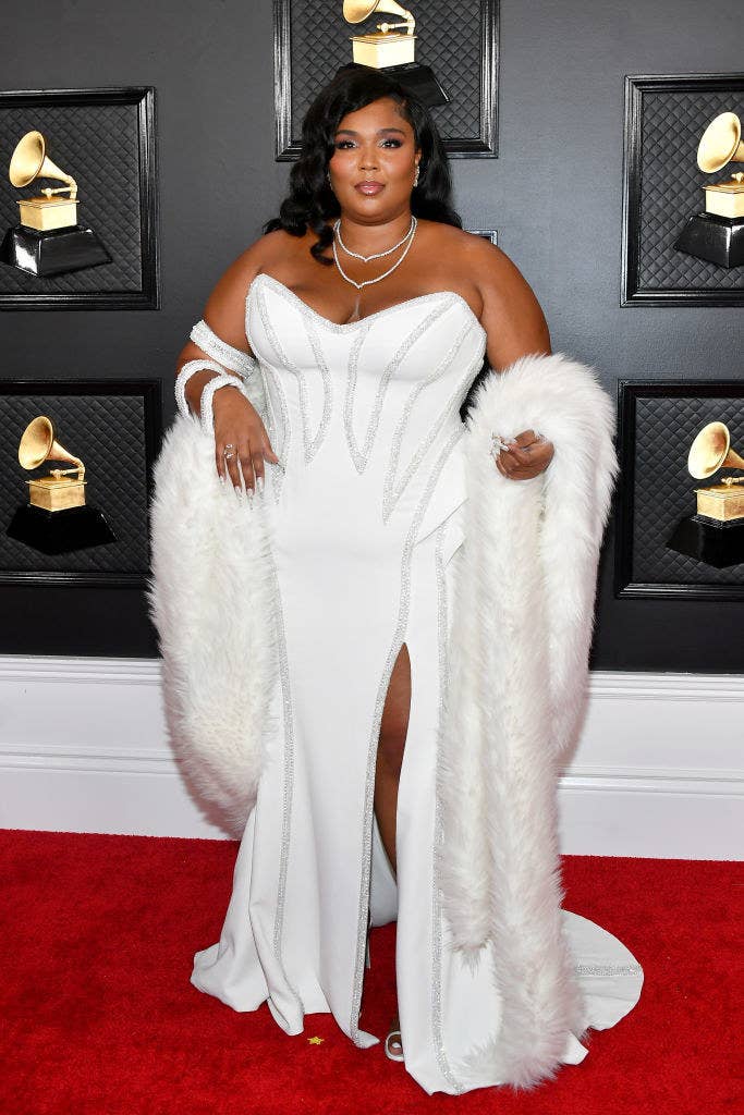 Lizzo wearing a strapless gown and stole on the Grammys red carpet