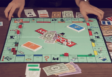 A GIF of someone flipping a Monopoly board over.