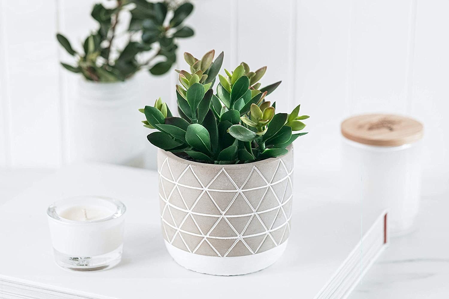 A faux succulent in a gray and white geometric pot