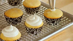 A GIF of someone piping frosting on top of a cupcake.