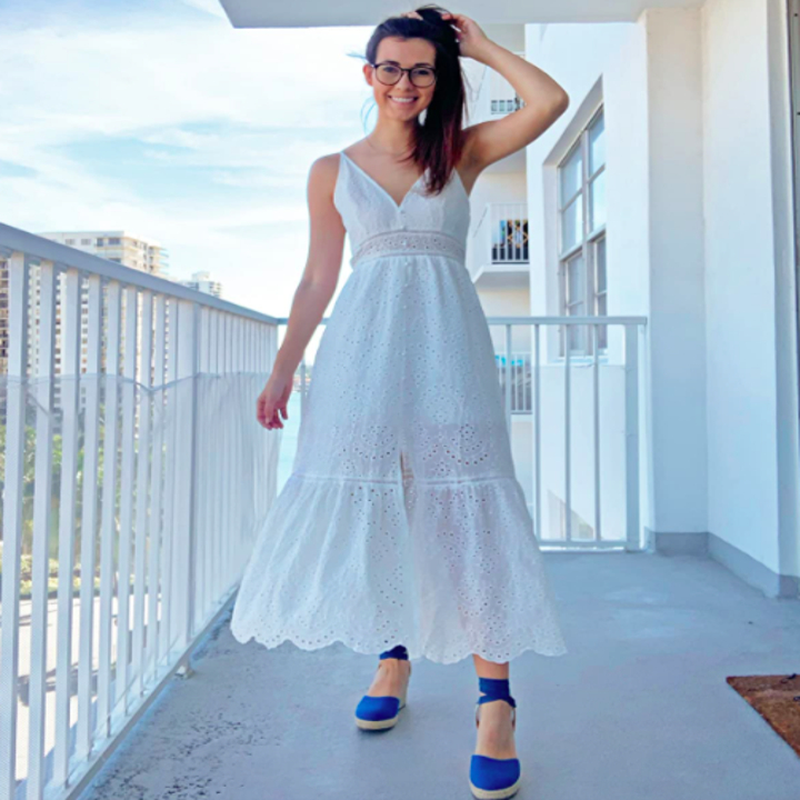 A customer review photo of them wearing the dress in white on a balcony