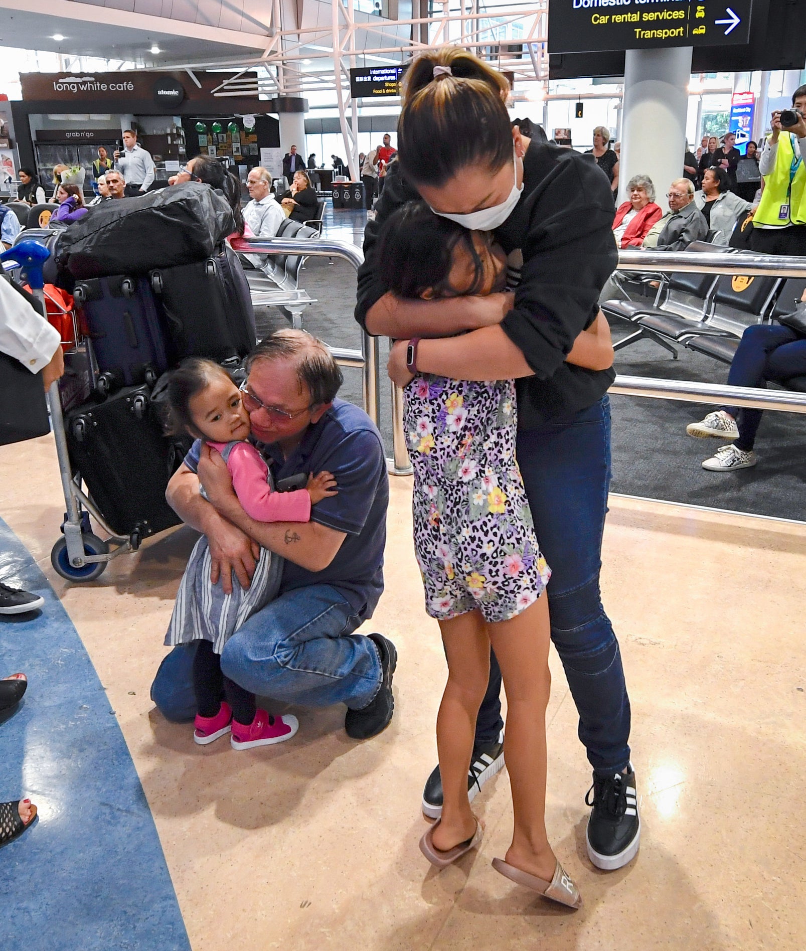 Two adults hugging children