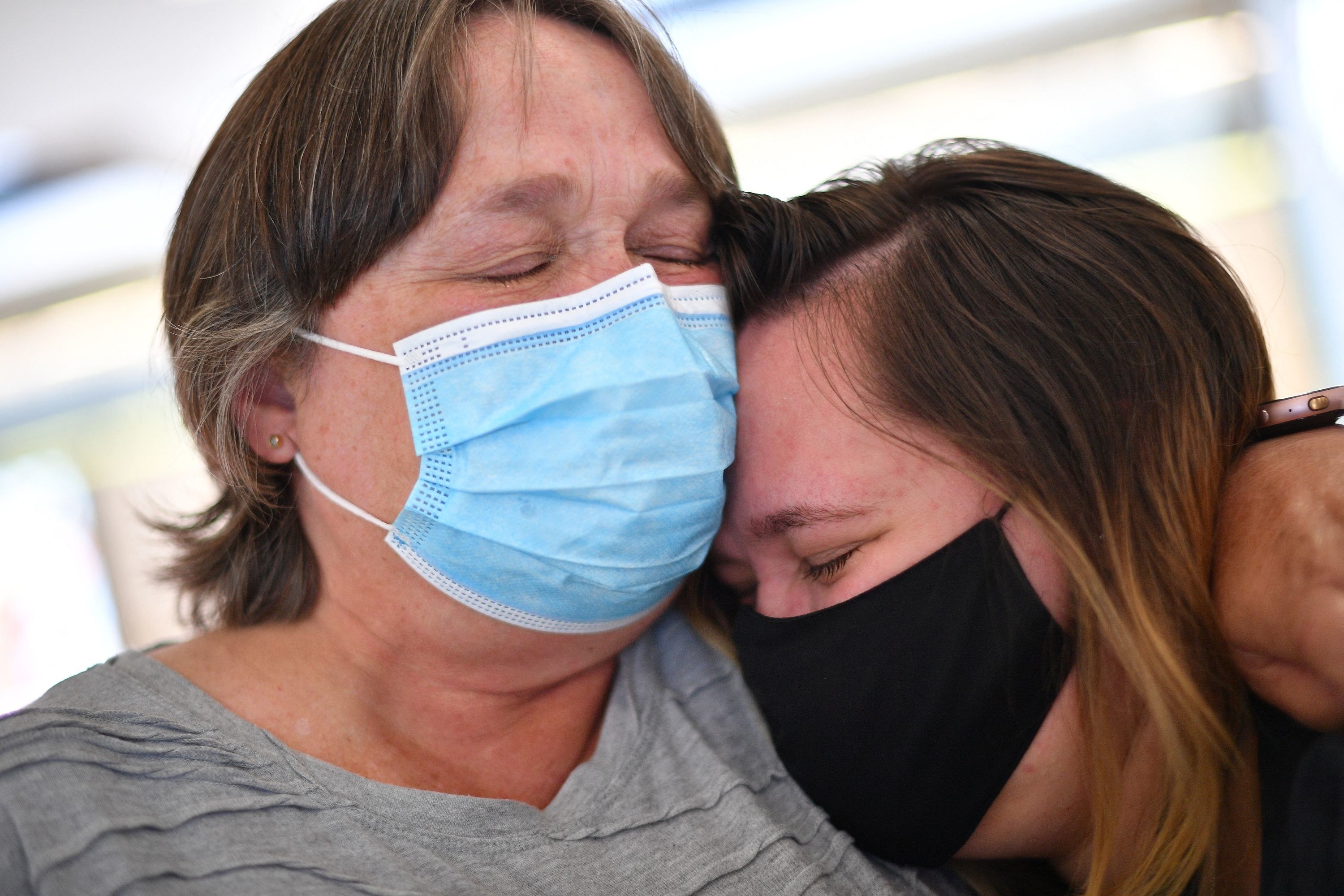 Two people crying as they embrace