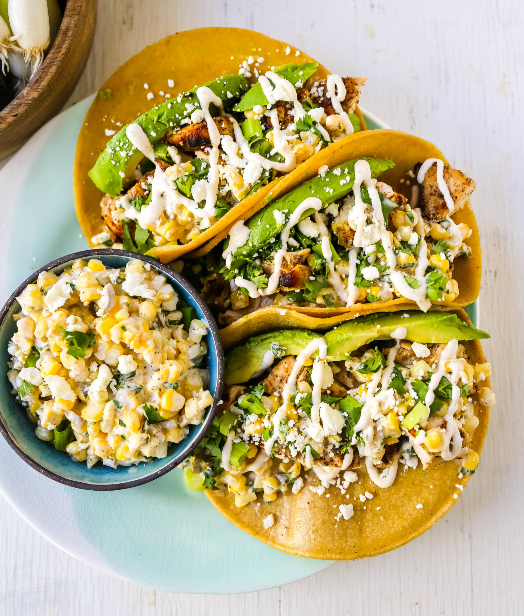 Chicken tacos with street corn and avocado. 